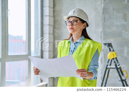 Technical profession woman in protective vest helmet working on construction 115466224