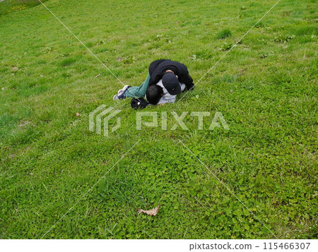 Children playing rolling around on the grass Children playing rolling around on the grass 115466307