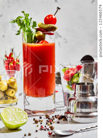 Highball of bloody mary cocktail in bar with utensils and lime,pepper,olives on light background. 115466574