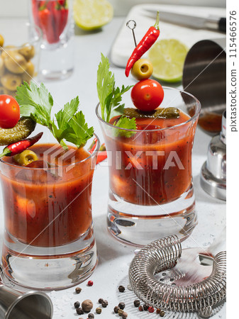 Bloody mary cocktail glasses with bar shaker and strainer with pepper and lime on light. 115466576