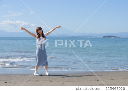 一個女人在陽光明媚的日子裡享受沙灘 一個女人在陽光明媚的日子裡享受沙灘 115467020