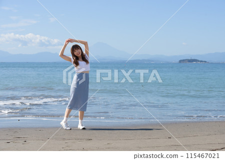 一個女人在陽光明媚的日子裡享受沙灘 115467021