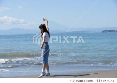 一個女人在陽光明媚的日子裡享受沙灘 115467025