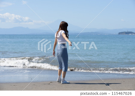 一個女人在陽光明媚的日子裡享受沙灘 115467026