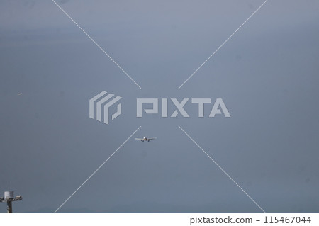 Aerial view of blue sky and an airplane with its lights on preparing to land Aerial view of blue sky and an airplane with its lights on preparing to land 115467044