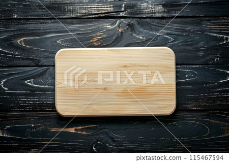 Clean wooden cutting board on dark wooden background 115467594