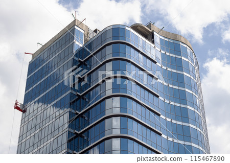 Describe a very tall building with numerous windows in an urban setting Describe a very tall building with numerous windows in an urban setting 115467890