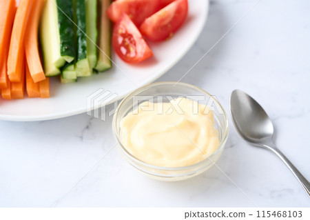 Mayonnaise and vegetable sticks served on a small plate 115468103