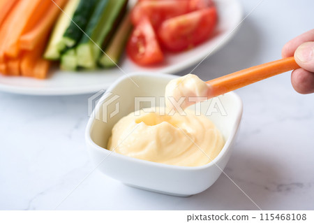 Mayonnaise and vegetable sticks served on a small plate 115468108