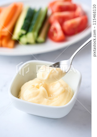 Mayonnaise and vegetable sticks served on a small plate 115468110