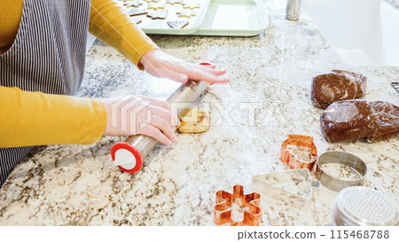 Using an adjustable rolling pin to roll out gingerbread cookie dough on the elegant marble counter in a modern kitchen, getting ready for festive holiday baking. 115468788