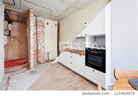 Photo collage of apartment before and after restoration or refurbishment. Comparison of old room and new kitchen with parquet floor, doorway, kitchen counter and white walls. Home renovation concept. Photo collage of apartment before and after restoration or refurbishment. Comparison of old room and new kitchen with parquet floor, doorway, kitchen counter and white walls. Home renovation concept. 115469973