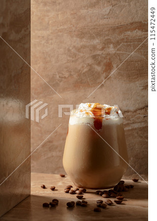Iced caramel latte topped with whipped cream and caramel sauce. Iced caramel latte topped with whipped cream and caramel sauce. 115472449