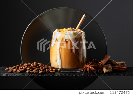 Iced coffee with whipped cream and caramel sauce on a black background. 115472475