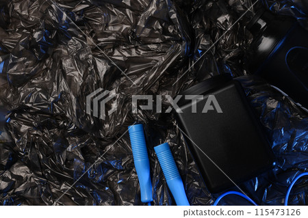 Jump rope, black plastic jar and bottle on dark background, space for text Jump rope, black plastic jar and bottle on dark background, space for text 115473126