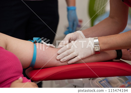 Laboratory and blood analysis concept. Close up cropped shot of professional nurse in gloves, taking a blood sample from arm vein of young female patient 115474194