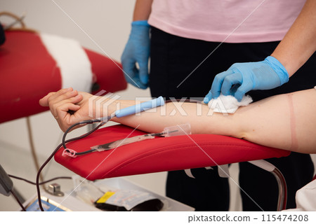 Laboratory and blood analysis concept. Close up cropped shot of professional nurse in gloves, taking a blood sample from arm vein of young female patient 115474208