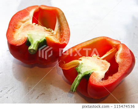 A red pepper, paprika vegetable, cut, lies on a white background, on a table. Proper healthy nutrition, vegetarianism, farming, cuisine, crop production, garden and vegetable garden A red pepper, paprika vegetable, cut, lies on a white background, on a table. Proper healthy nutrition, vegetarianism, farming, cuisine, crop production, garden and vegetable garden 115474536