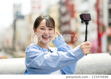 Young and pretty woman taking a selfie in the city's downtown | Osaka Tourism Image | Dotonbori, Osaka Prefecture | Ebisubashi Bridge 115474696