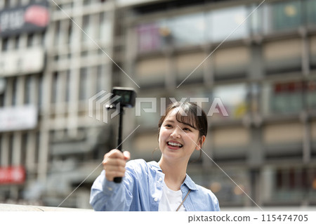 Young and pretty woman taking a selfie in the city's downtown | Osaka Tourism Image | Dotonbori, Osaka Prefecture | Ebisubashi Bridge 115474705