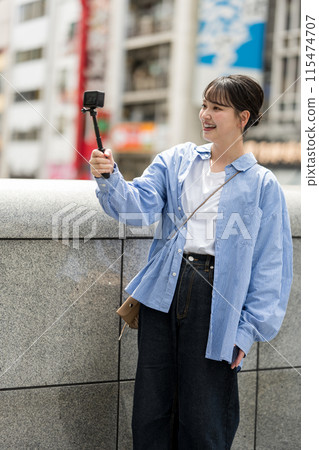Young and pretty woman taking a selfie in the city's downtown | Osaka Tourism Image | Dotonbori, Osaka Prefecture | Ebisubashi Bridge 115474707