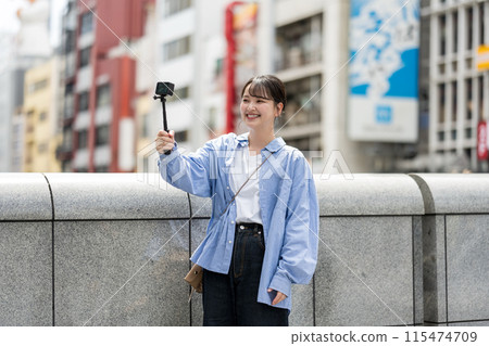 Young and pretty woman taking a selfie in the city's downtown | Osaka Tourism Image | Dotonbori, Osaka Prefecture | Ebisubashi Bridge 115474709