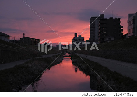 A river in a residential area dyed in the sunset 115474852