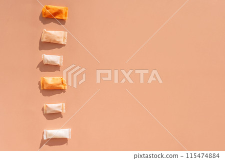 Snus bags with different flavors in a row on an orange background Snus bags with different flavors in a row on an orange background 115474884
