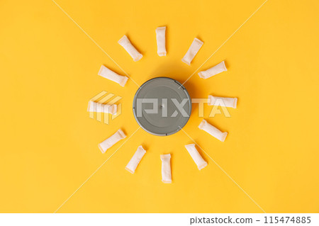 White thin snus sachets are laid out around a round jar on a yellow background 115474885