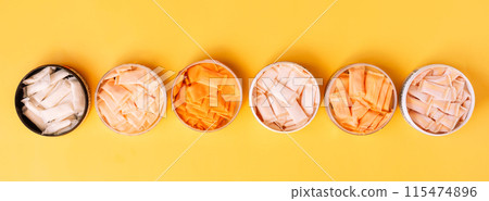 Multi-colored snus sachets with different flavors are placed in jars on a yellow background Multi-colored snus sachets with different flavors are placed in jars on a yellow background 115474896