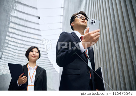 走在走廊裡的男性和女性商人 走在走廊裡的男性和女性商人 115475542