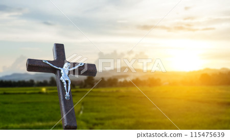 A red wooden cross on a blurred cemetery background. A red wooden cross on a blurred cemetery background. 115475639