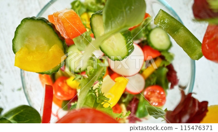 Top View of Flying Vegetable Pieces into Salad Bowl. Top View of Flying Vegetable Pieces into Salad Bowl. 115476371