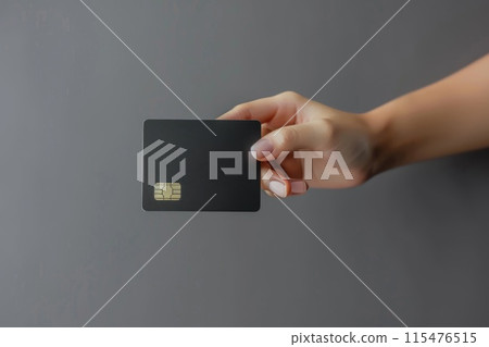 A woman's hand holding a black square on a bank card, Credit card female hand holding 115476515