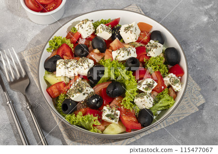 Salad with olives and cucumbers, tomatoes, cheese and sauce. Boiled egg. 115477067