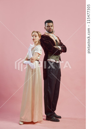 Elegant Alliance. A man and woman dressed in elegant renaissance costumes, stand back-to-back and posing against pink studio background Elegant Alliance. A man and woman dressed in elegant renaissance costumes, stand back-to-back and posing against pink studio background 115477305