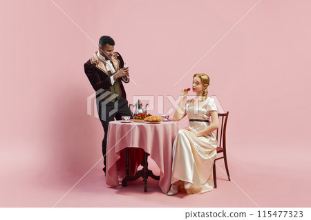 Historical Breakfast with a Tech Twist. Man taking photo with phone of elegant young woman against pink studio background Historical Breakfast with a Tech Twist. Man taking photo with phone of elegant young woman against pink studio background 115477323