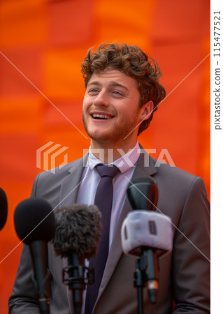 Young Caucasian male businessman being interviewed by a reporter. 115477521