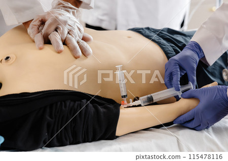 Medical Student Practicing Intravenous Injection on Training Dummy Medical Student Practicing Intravenous Injection on Training Dummy 115478116