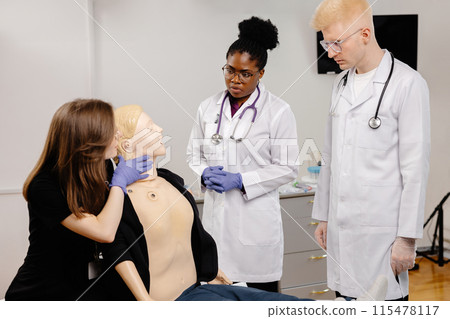 Medical Students Practicing First Aid on a Dummy in a Classroom 115478117