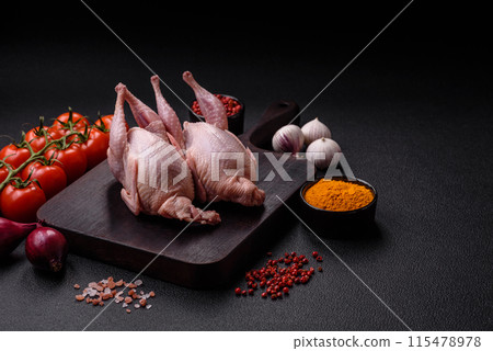Whole raw quails with salt, spices and herbs on a dark concrete background Whole raw quails with salt, spices and herbs on a dark concrete background 115478978