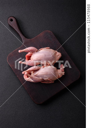Whole raw quails with salt, spices and herbs on a dark concrete background Whole raw quails with salt, spices and herbs on a dark concrete background 115478988