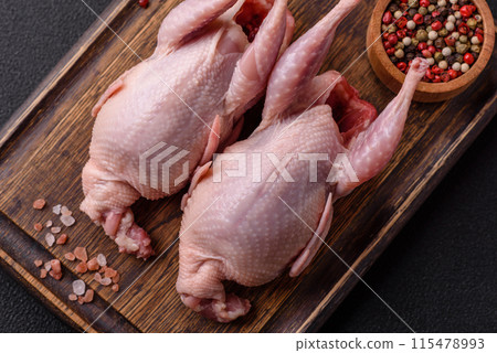 Whole raw quails with salt, spices and herbs on a dark concrete background 115478993