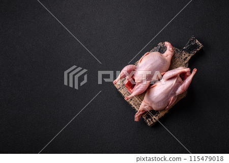 Whole raw quails with salt, spices and herbs on a dark concrete background Whole raw quails with salt, spices and herbs on a dark concrete background 115479018