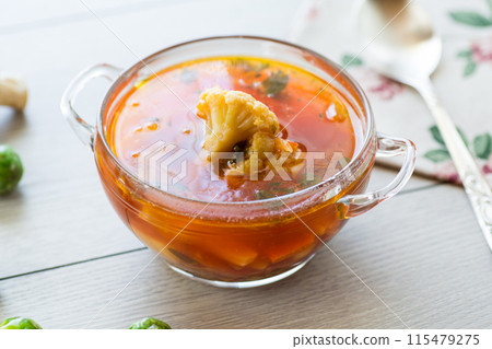 vegetable soup with Brussels sprouts and cauliflower, in a glass plate on a wooden table vegetable soup with Brussels sprouts and cauliflower, in a glass plate on a wooden table 115479275