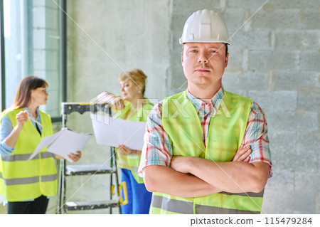 Young male industrial worker in safety helmet vest at construction site inside Young male industrial worker in safety helmet vest at construction site inside 115479284