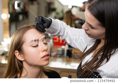 Beauty master drawing contour for brow correction.  115479492