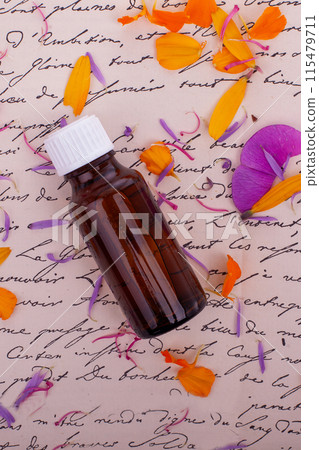 Amber Bottle with Petals on Script. Bach Therapy 115479711