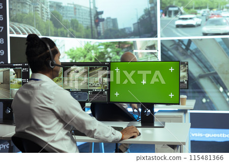 Indian specialist monitoring traffic surveillance next to a greenscreen display, gather intelligence on traffic activity in the city. Government employee collecting data on cars, plate recognition. Indian specialist monitoring traffic surveillance next to a greenscreen display, gather intelligence on traffic activity in the city. Government employee collecting data on cars, plate recognition. 115481366