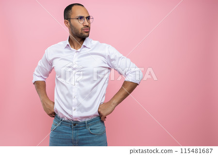 Serious man in white shirt looking away with hands on hips Serious man in white shirt looking away with hands on hips 115481687